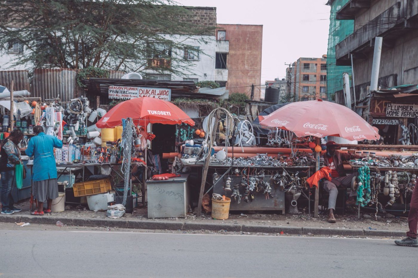 Busy Nairobi street market beneath red umbrellas